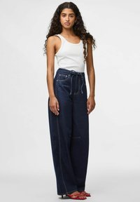 Høytlivede mørke denimbukser med knytebelte, med en rett bendesign, synlig søm, og to frontlommer.