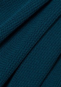 Strickstoff mit einem strukturierten Muster in einem tiefen Tealton, der eine weiche, dicke Webart aufweist, die eine erhabene Oberfläche schafft.