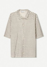 Kortärmad skjorta i grädde med ett svart zigzag-mönster. Har en krage och knappar framtill, tillverkad av strukturerat tyg.