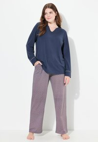 Marineblå langærmet top med V-hals og mønstrede lilla pyjamasbukser. Bukserne har et lille blomstermønster og en afslappet pasform.
