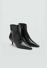 Črne usnjene gležnjarje s koničastim nosom, zadrgo in ožjim, kitten peto. Gladka tekstura z elegantnim, minimalističnim dizajnom.