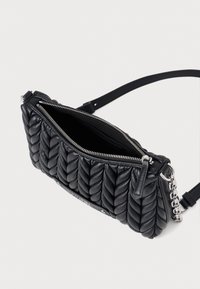 Fekete steppelt bőr kézitáska cipzárral, lánc díszítéssel és sík pánttal. A belseje sima anyaggal van bélelve.