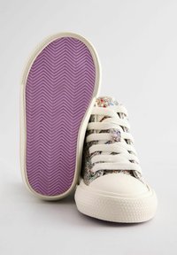 Baskets en toile colorées remplies de paillettes avec des lacets blancs et des embouts en caoutchouc ; semelle extérieure texturée violette avec un motif en chevrons.