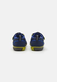 Granatowe buty z textured wykończeniem, z limonkowymi akcentami, z paskiem na rzep oraz wyściełanym tyłem dla większego komfortu.