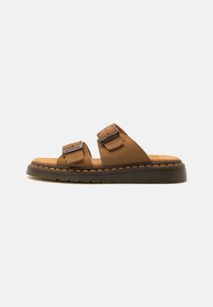 Brown leather sandals with two adjustable straps, textured surface, padded footbed, and a thick rubber sole with orange stitching accents.