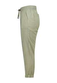 Pantalons de jogging vert clair avec une taille élastique, un cordon de serrage, des poches latérales et des chevilles cintrées. Tissu lisse avec une texture subtile.