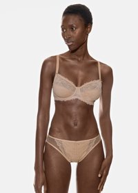 Ensemble de soutien-gorge et culotte assortis en nude avec des bordures en dentelle, présentant un tissu semi-transparent, de délicats accents en nœud et des bords festonnés pour plus de détails.