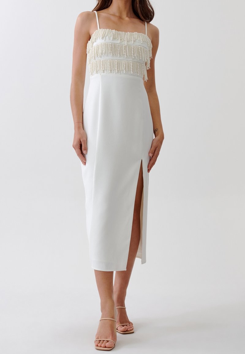 Bílé midi šaty s třásňovým, texturovaným korpusem, tenkými ramínky a bočním rozparkem. Hladká látka, minimalistický design a uhlazený silueta.