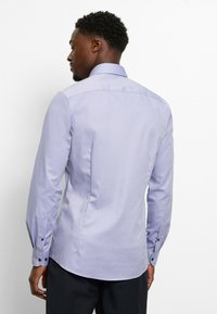 Light purple long-sleeve shirt with a tailored fit, featuring a smooth texture, buttoned cuffs, and a pointed collar.