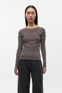 Bruin- en crème gestreept langarmshirt met een ronde hals, gemaakt van een geribbelde stof, gecombineerd met donkergrijze broek met hoge taille.