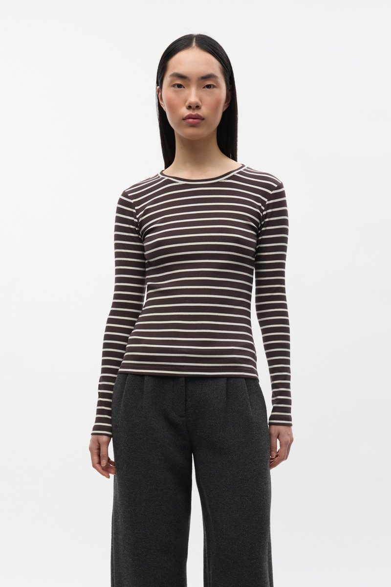 Bruin- en crème gestreept langarmshirt met een ronde hals, gemaakt van een geribbelde stof, gecombineerd met donkergrijze broek met hoge taille.