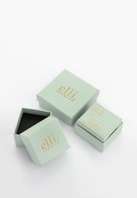 Green, square gift boxes made of textured cardstock with gold foil accents. One box is open, revealing a black interior.