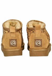 Botas de tobillo de ante marrón con detalles de leopardo, forro de piel de pelo y suela de goma plana. Presentan un parche de marca en la parte trasera y tiradores en bucle.