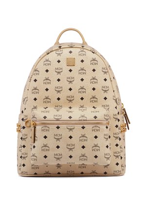 Beige leren rugzak met gouden ritssluiting en studs, bedekt met zwarte MCM-logo patronen en diamanten vormen, voorzien van een bovenhandvat en een voorvak.