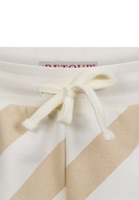 Pantaloni della tuta a righe beige chiaro e crema con una consistenza morbida, dotati di vita con coulisse e di un'etichetta con la scritta "RETOUR."