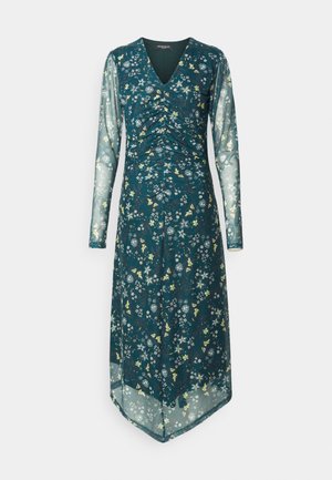 Floral print dress in dark teal with long sheer sleeves, V-neckline, ruched bodice, and asymmetrical hem. Features yellow and white accents.