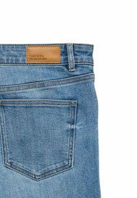 Hele sinised teksapüksid nahast brändiplaadiga, viiekohilise disainiga ja markantse õmblusega tagapõlves.