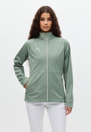 Chaqueta verde claro con cremallera, hecha de un tejido liso y elástico. Presenta un cuello alto y un logo discreto en el pecho izquierdo. Textura suave.