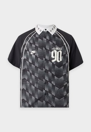 Czarna i szara koszulka Nike z krótkim rękawem z geometrycznym wzorem, białym kołnierzem z małymi logo, białym obszyciem i tekstem "Air Max 90" na przodzie.