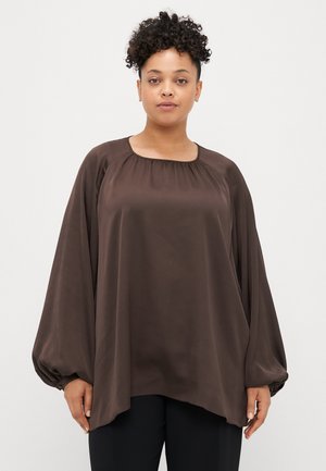 Bruine, vloeiende blouse met lange mouwen en een ronde halslijn, met gerimpelde details op de schouders en elastische manchetten. Soepele, lichte stof.