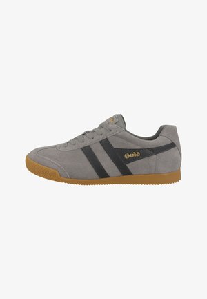 Gray suede sneaker with black side stripes, rubber gum sole, and embossed logo on tongue. Minimalistic design with lace-up closure.
