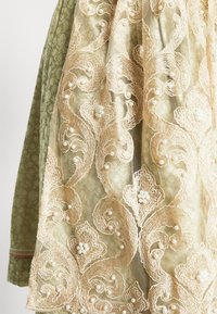 La robe à superposition de dentelle présente une broderie florale dorée complexe et des perles sur un tissu vert texturé et atténué, offrant profondeur et détails.