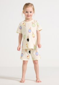 Romige katoenen pyjama's met een speels patroon van ijsjes in verschillende kleuren. Korte mouwen top met bijpassende shorts.