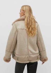 Beige Lederjacke mit einem Kunstpelzkragen, mit strukturiertem Finish, weiten Ärmeln und einem taillierten Schnitt mit akzentuierter Naht.