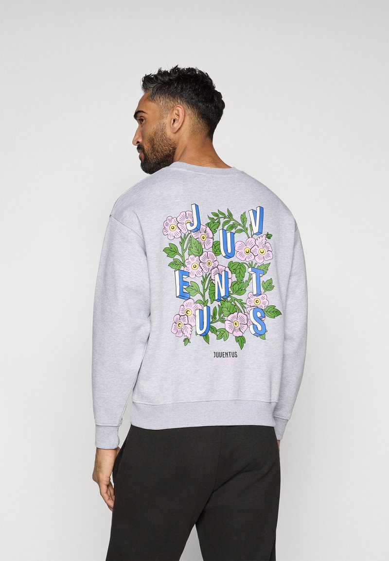 Felpa grigia con grafiche floreali e la scritta "JUVENTUS" in lettere blu e rosa, con polsini e orlo a coste.