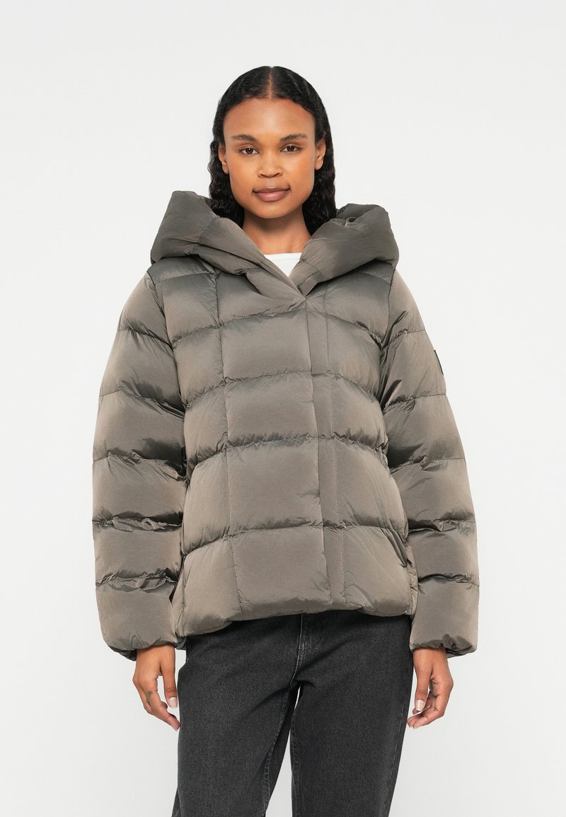 Veste rembourrée de couleur olive atténuée, dotée d'une capuche, d'un design matelassé et de manches larges. Texture lisse avec des coutures horizontales.