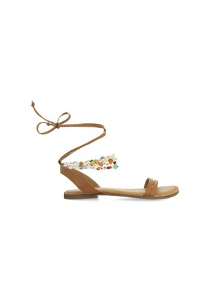 Sandalia de cuero marrón con suela plana, dos correas sobre el pie y una correa de tobillo con cuentas que presenta diversos elementos decorativos de colores.