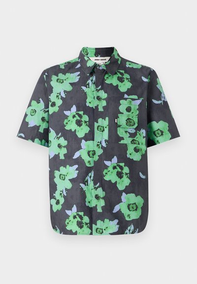 Camisa de manga corta en tela oscura con un gran estampado floral en verde y azul claro. Incluye un bolsillo en el pecho con tapa.