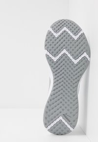 Semelle de basket en caoutchouc gris avec un motif en zigzag, présentant des rainures texturées et un accent blanc sur le côté, marqué "Running".