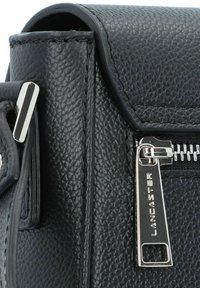 Black textured leather handbag with a zip closure and silver hardware. Features a flap cover and visible stitching along edges.