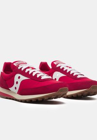 Sneakers rossi con accenti bianchi, realizzati in materiali scamosciati e rete, punta rotonda, design con lacci e suola in gomma con dettagli testurizzati.