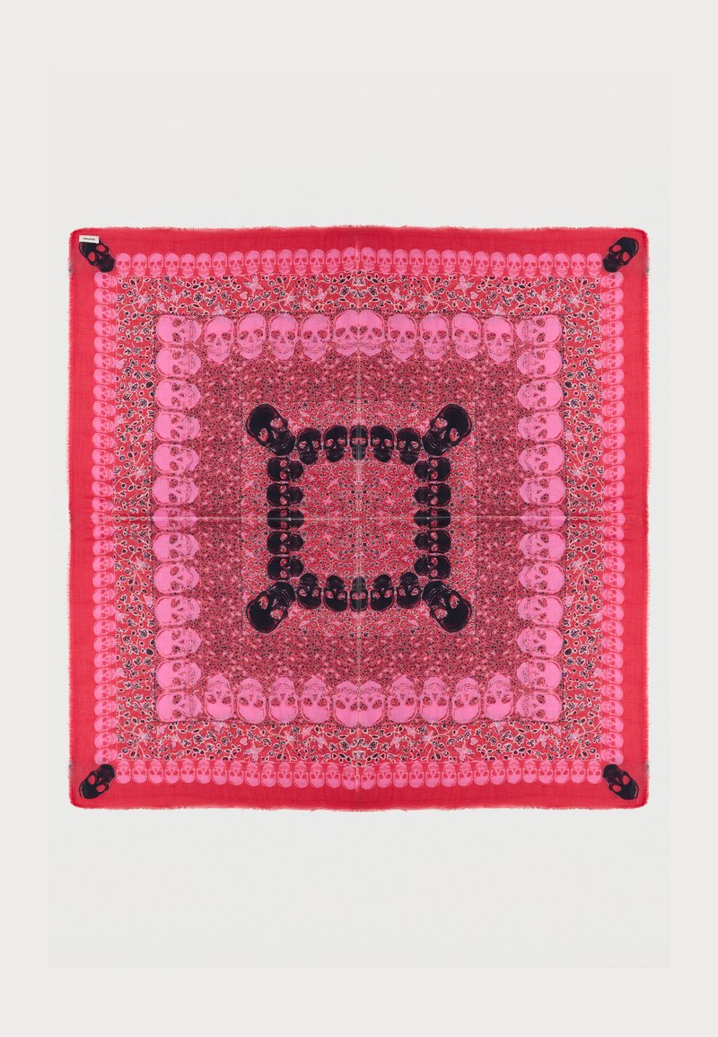 Κόκκινο και ροζ τετράγωνο μαντήλι με πολλές σειρές από μοτίβα κρανίων με λουλουδόσχημες λεπτομέρειες και μεγαλύτερα μαύρα κρανία σε κάθε γωνία.