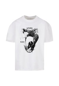 Fehér pamut póló, amelynek grafikai mintája egy fekete kígyó fejét ábrázolja, a "2y Studios" felirattal fent, és a "No Fear" felirattal lent.