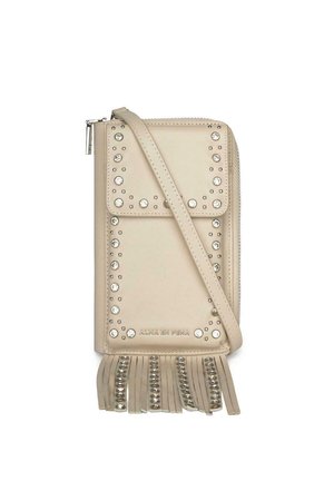 Bolso bandolera beige con tachuelas plateadas que delinean la solapa frontal y flecos con tachuelas en la parte inferior, con cierre de cremallera.