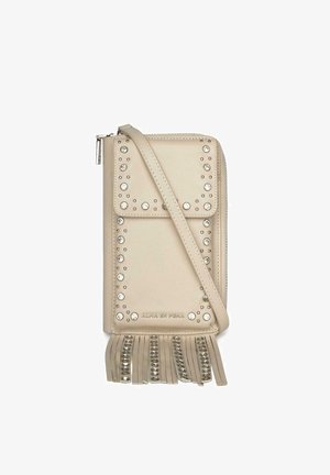 Bolso bandolera beige con tachuelas plateadas que delinean la solapa frontal y flecos con tachuelas en la parte inferior, con cierre de cremallera.