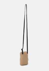 Borsa a tracolla texturizzata color tan con tracolla nera regolabile, forma rettangolare, scomparti con doppia zip e dettagli in metallo argentato.