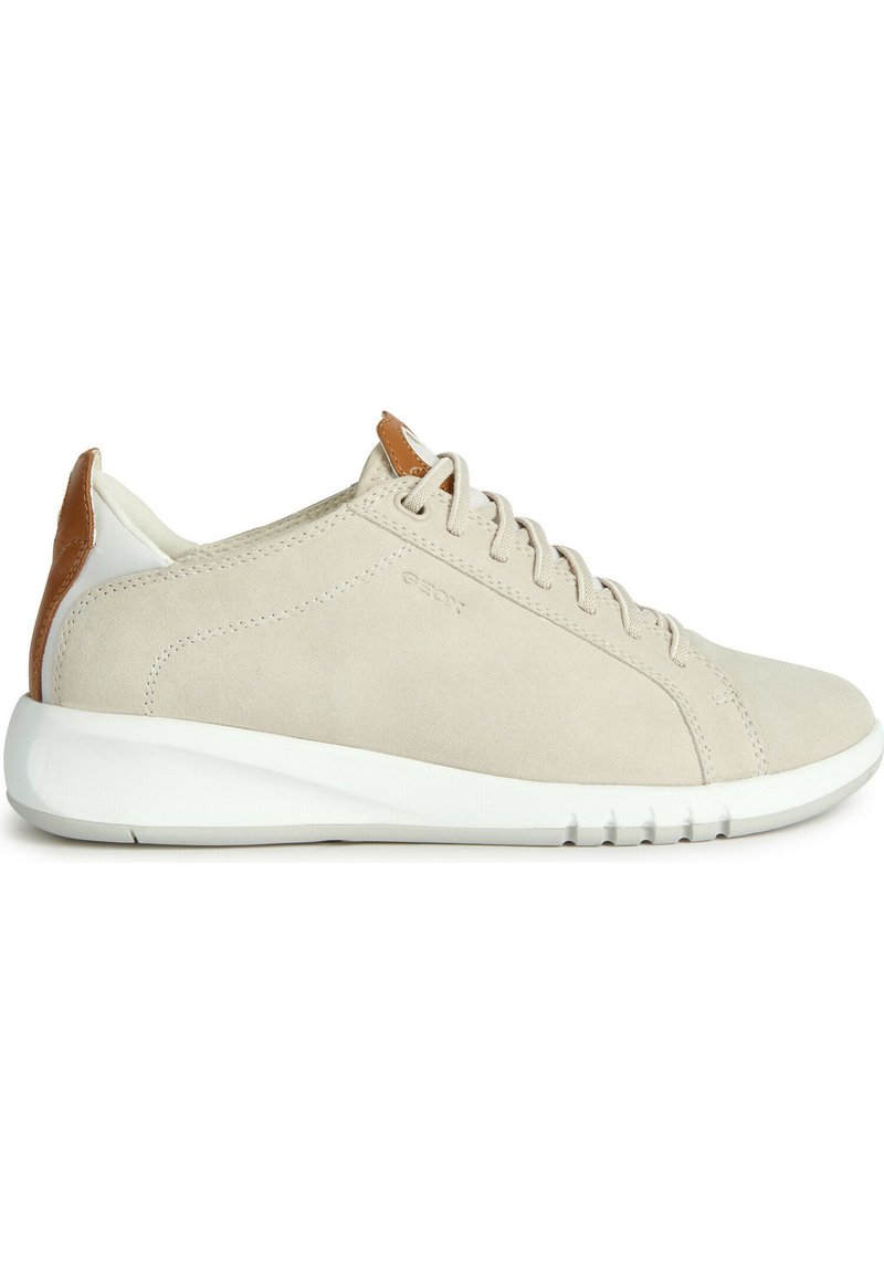 Zapatilla de ante beige con suela de goma blanca, con un acento de cuero marrón en el tacón y cierre clásico con cordones.