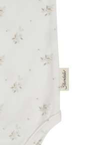 White cotton bodysuit with small beige floral pattern, featuring a smooth texture and a tag that reads "Stemtaale."