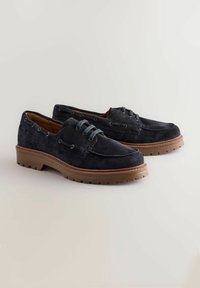 Pantofi din suede de culoare bleumarin cu talpă din cauciuc, având un design cu șireturi, cusături contrastante și ochiuri metalice. Formă standard cu vârful rotund.