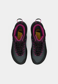 Sapatos de caminhada em preto e cinza com detalhes e atacadores em rosa, apresentando uma sola robusta, colarinho acolchoado e alças para facilitar o uso.