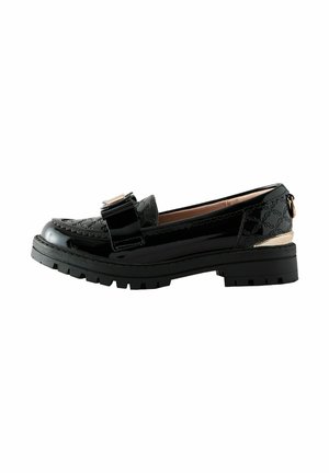 Schwarze Lacklederloafers mit strukturellem Design, erhabenen Nähten und einer dekorativen Schleife. Klobige schwarze Sohle mit goldenen Akzenten.