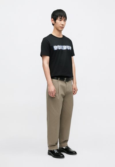 Μαύρο βαμβακερό T-shirt με το γράφημα "DON DUP", σε συνδυασμό με μπεζ παντελόνι και μαύρα δερμάτινα  παπούτσια, με απλό σχέδιο και άνετη εφαρμογή.