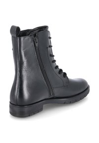 Stivale alla caviglia in pelle nera con punta arrotondata, zip laterale a contrasto e lacci sulla parte frontale, dotato di suola robusta e texture liscia.