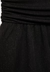 Fekete ruched fazonú ruha; a texturált anyag szórt, finom csillogással rendelkezik, és derékrészből lefelé áramlik. Simas, könnyű anyagból készült.