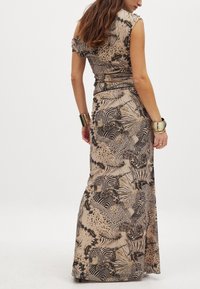 Maxikleid in Beige mit schwarzen Tier- und Blumenmustern; kurze Ärmel, taillierter Oberteil und fließender Rock, der eine glatte Textur aufweist.