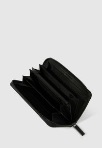 Portefeuille en cuir noir avec fermeture éclair, doté de plusieurs emplacements pour cartes, de compartiments divisés et d'une finition texturée.